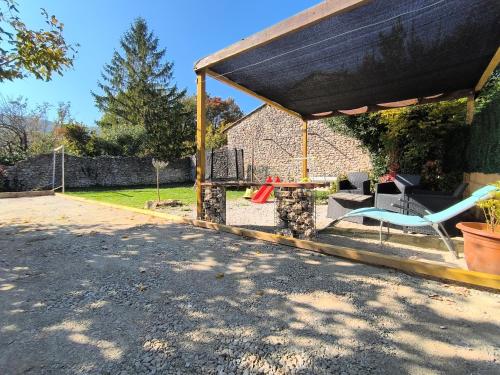 un pabellón con una mesa y sillas en un patio en la tour du forgeron, en Rochefort-en-Valdaine