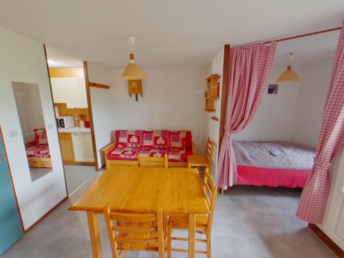 a room with a table and a bed and a bedroom at Studio lumineux avec loggia aux Rousses - FR-1-834-12 in Les Rousses