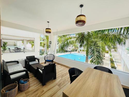 a living room with a table and chairs and a pool at Bayahibe in Bayahibe