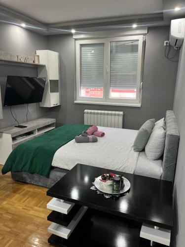 a small bedroom with a bed and a table at Apartman Hram Zvornik in Zvornik