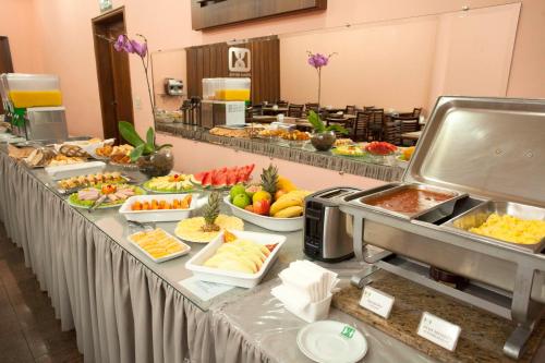 uma linha de buffet com muitos tipos diferentes de alimentos em Indaiá Hotel Residence em São Carlos