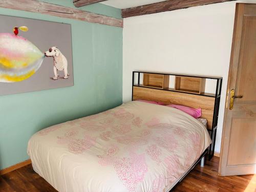 a bedroom with a bed and a picture of a dog at La casa di Alba-Salomé in Métairies-Saint-Quirin