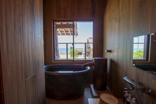 a bathroom with a large tub next to a window at 洗心和方 Senshin Waho in Awaji