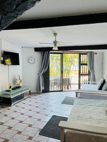 a bedroom with two beds and a television and a patio at Broadway Shark Guest House in Margate