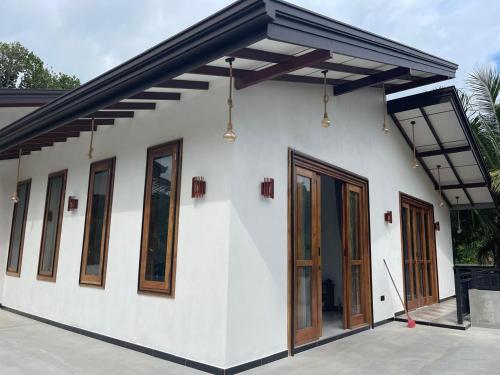 a white house with wooden doors and windows at The Wasa Heaven in Hiriketiya