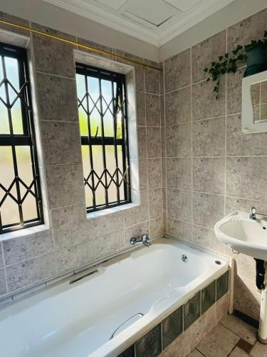 a bath tub and a sink in a bathroom at Broadway Shark Guest House in Margate
