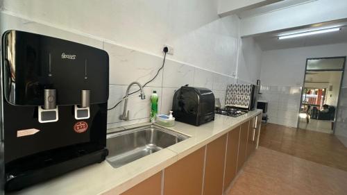 a kitchen with a sink and a microwave at 3 Bedrooms Single Storey Terrace at Taman Inderawasih ,12mins to Penang Bridge , 5mins to Sunway Carnival Mall in Butterworth