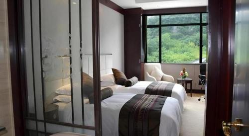 a bedroom with two beds and a large window at West Lake Hillview Int'L Hotel in Hangzhou