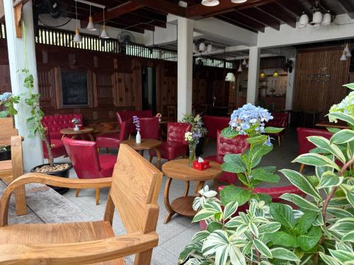 a restaurant with red chairs and tables and flowers at Pak Chiang Mai in Chiang Mai