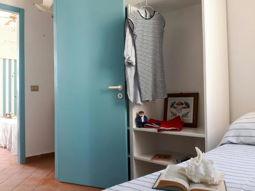 サンピエリにあるMaredentroの青いドアと本付きのベッドが備わるベッドルーム1室が備わります。