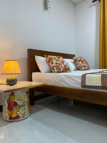 a bedroom with a bed and a table with a lamp at Rhythm Transit Hotel - Near Airport in Katunayaka