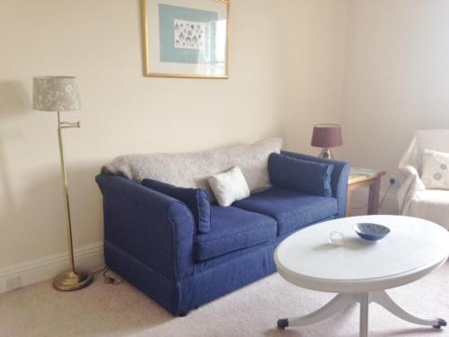 a living room with a blue couch and a table at The Haven in Rothbury