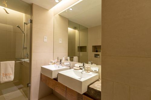 a bathroom with two sinks and a mirror at The Palm Retreat 1BR in St Regis Residences Saadiyat in Abu Dhabi