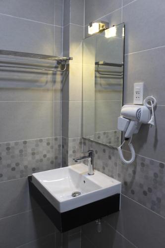 a bathroom with a sink and a mirror at Sunny Guesthouse2 in Ho Chi Minh City