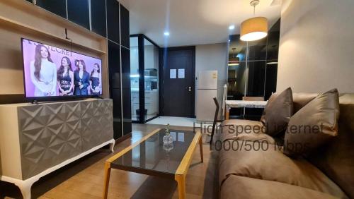 a living room with a couch and a flat screen tv at 1BR Thonglor , Fast WiFi , Near Samitivej , Nightlife in Klong Toi