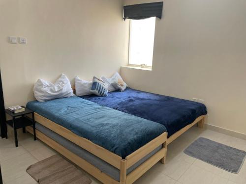 a bedroom with a bed with blue sheets and a window at Ladies only Feel like at home, among sisters in Ajman