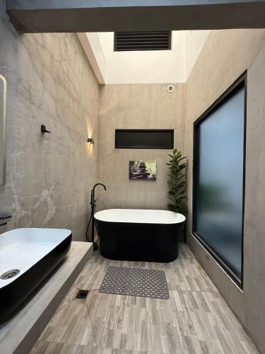 a bathroom with a bath tub and a sink at A's Hideaway Pampanga in Guagua