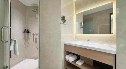 a bathroom with a sink and a shower with a mirror at Howard Johnson by Wyndham Sunshine Plaza Ningbo in Ningbo