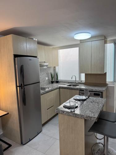 a kitchen with a stainless steel refrigerator and cabinets at Departamento Ejecutivo de Lujo in Monterrey