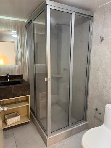 a glass shower in a bathroom with a sink at Departamento Ejecutivo de Lujo in Monterrey
