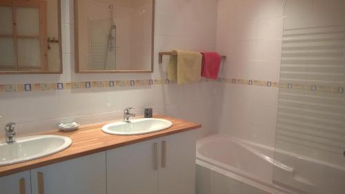 a bathroom with two sinks and a bath tub at Le Tilleul de Ray in Ray-sur-Saône