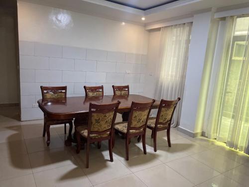 a dining room with a wooden table and chairs at KiGALI HORIZON HOMES in Kigali