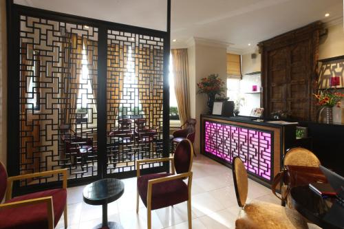 a restaurant with a bar and a large window at Mayflower Hotel in London