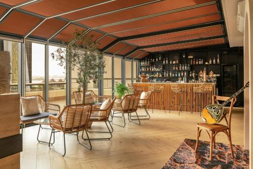 a restaurant with chairs and a bar with windows at Aloft Palm Jumeirah in Dubai