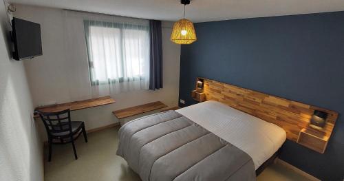 a bedroom with a bed and a table and a chair at N'Atura Hôtel in Aire-sur-lʼAdour