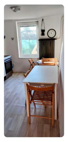 a room with a table and a clock on the wall at Domeček v Týně pod Helfštýnem in Týn nad Bečvou