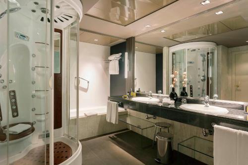 a bathroom with two sinks and a shower at Madrid Marriott Auditorium Hotel & Conference Center in Madrid