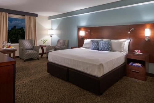 a hotel room with a bed and a desk and chairs at Millennium Durham in Durham