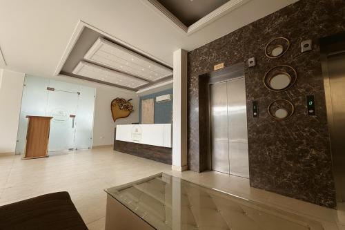 a room with a glass table and a wall with clocks at The Ruby Resort, Vrindavan # Prime Location # Luxury Rooms # Near Prem Mandir # Restaurant # Big Lawn # Big Parking # By Nandan Group # in Vrindāvan