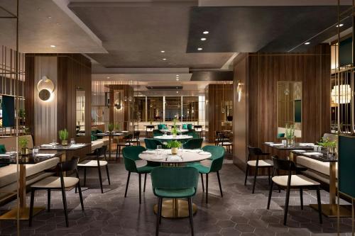um restaurante com mesas e cadeiras em uma sala em Sheraton Milan San Siro em Milão
