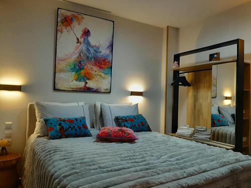 a bedroom with a bed with a large painting on the wall at Ioni Home in Tsagarada