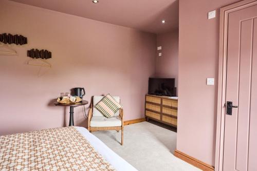 a bedroom with a bed and a table with a chair at The Bulls Head in Belper