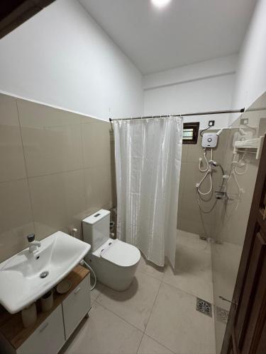a bathroom with a toilet and a sink at Avira Cozy Corner in Kilinochchi