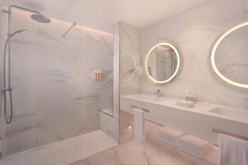a white bathroom with a shower and a sink at Delta Hotels by Marriott Azores in Ponta Delgada