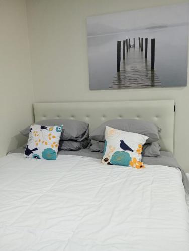 a bed with two pillows and a picture of a pier at The Rice Chiang Dao in Ban Thung Lakhon