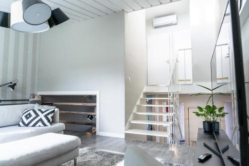 een woonkamer met een trap en een bank bij Apartment Siihtala - suuri saunallinen huoneisto in Joensuu