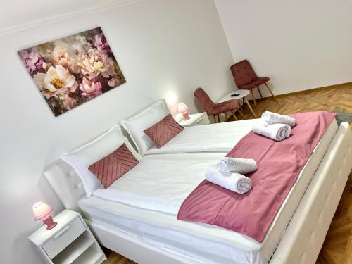 ein Schlafzimmer mit einem weißen Bett mit Handtüchern darauf in der Unterkunft Luxury Apartment in Făgăraş