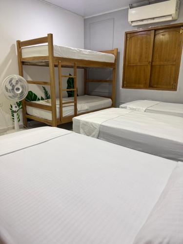 a room with three beds and a bunk bed at Hostal Cilipo in Palomino