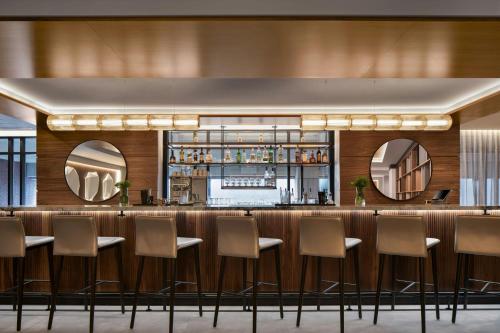 a bar in a hotel with chairs and mirrors at AC Hotel by Marriott Old Montreal in Montréal