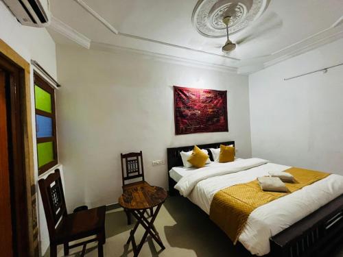 une chambre avec deux lits, une table et une chaise dans l'établissement Classic Villa - Near Jaisalmer Fort, à Jaisalmer