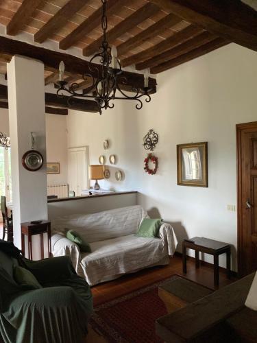 a living room with a couch and a chandelier at Le Due Querce in Vicolo Rancolfo