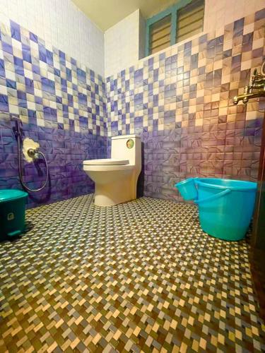 a bathroom with a toilet and a blue tub at Lake and Paddy holiday home in Alleppey