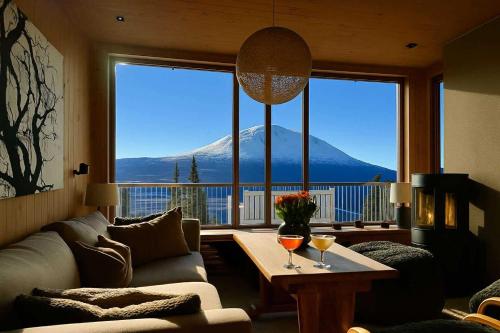 a living room with a view of a mountain at Astonishing Mountain Lodge at the top of Gaustablikk, 25m2 west facing terrace, 3 bedrooms in Gaustablikk