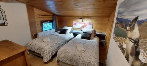 a bedroom with two beds and a horse picture on the wall at La Maison de Charlie Les 2 Alpes in Les Deux Alpes