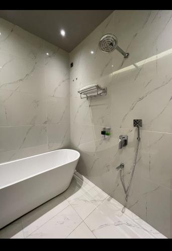 a white bathroom with a tub and a shower at Exotica Stays in Alibaug