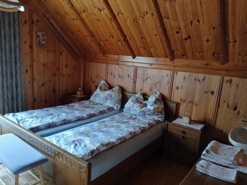 una cama en una habitación con techo de madera en Haus Lois, en Weissbriach